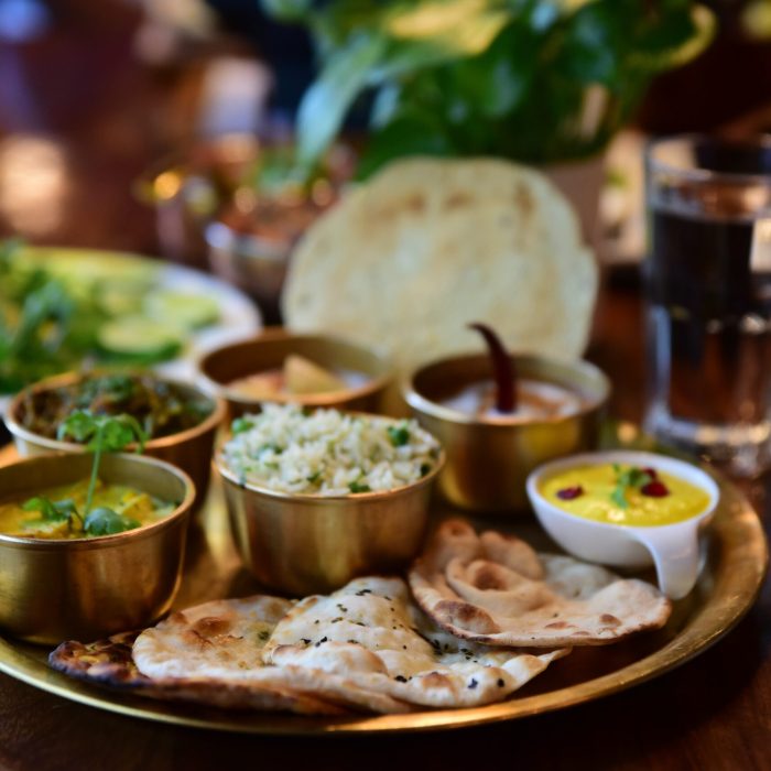 A closeup shot of an Indian tasty food called "Marwari Veg Thali" on the wooden table